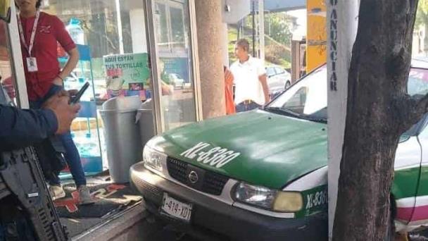 Taxi se sube a banqueta en Xalapa y choca contra señalética