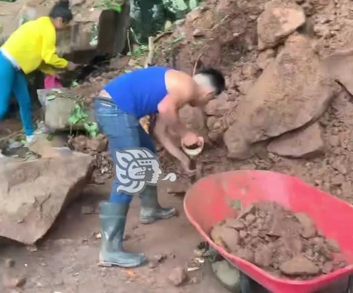 Ante la falta de apoyo, habitantes de Yecuatla retiran piedras y lodo de un deslave